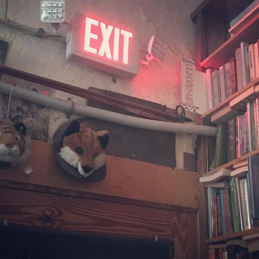 glowing red exit sign over the top of a door frame, casting a red light