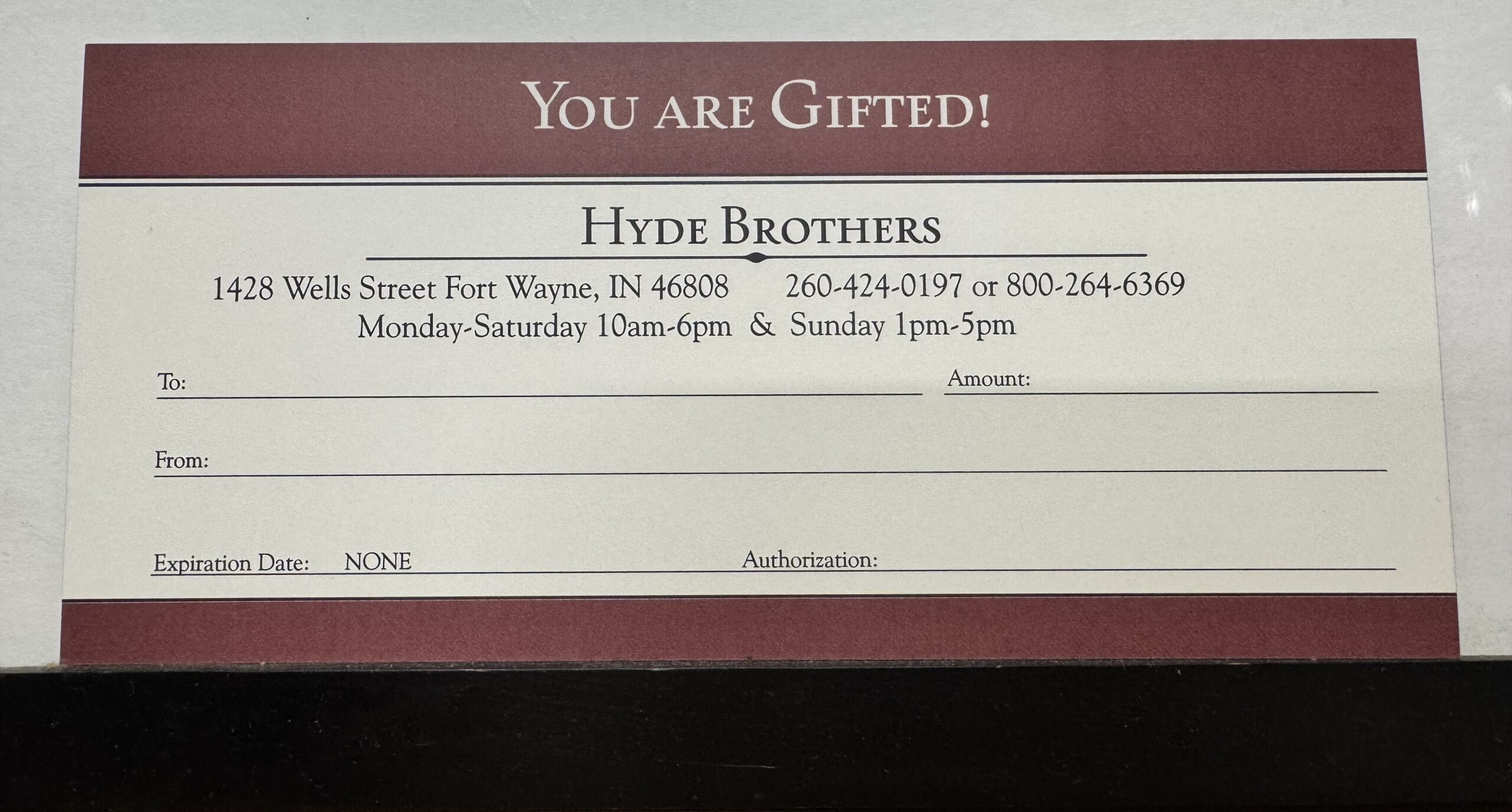 picture of the physical, red and cream colored Hyde Brothers Gift Certificate which contains blank fields for to and from, amount, and a signature.